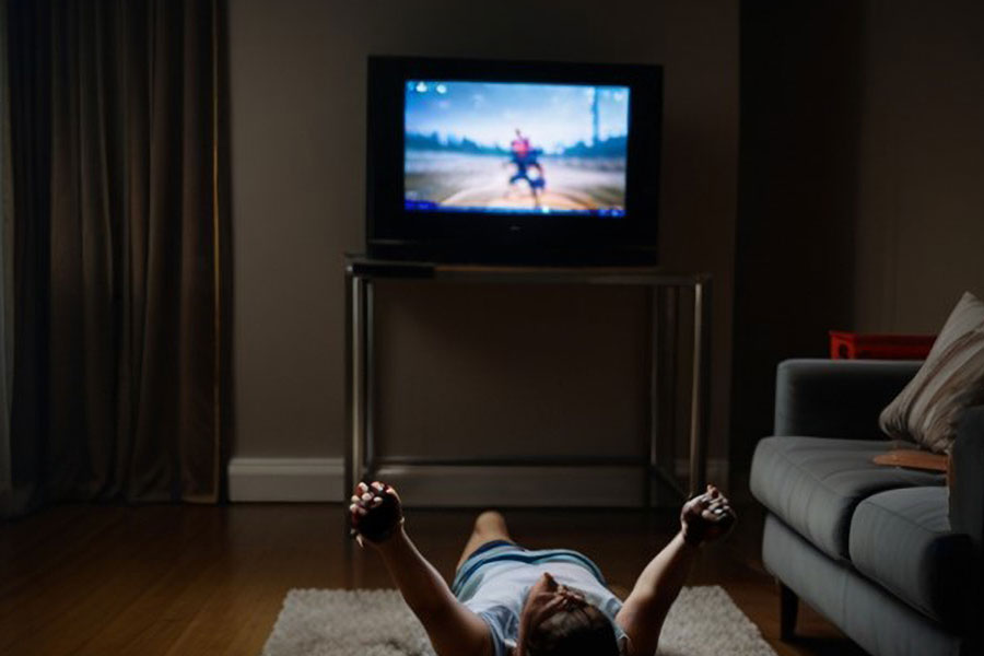 a person in a room exercising in front of a tv while playing games. Working out while playing video games can help you avoid pain in certain areas of your body.