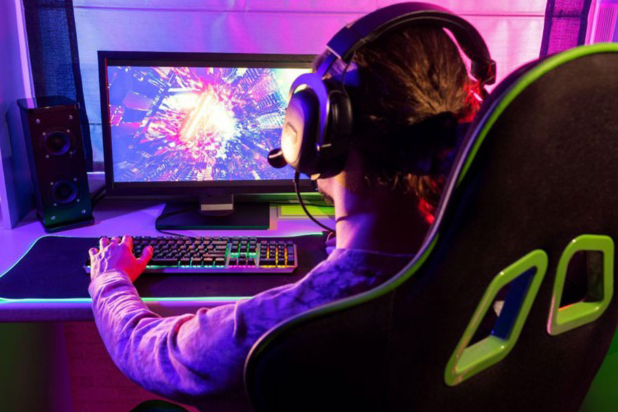 A pro gamer sitting in a gaming chair and playing games with his pc.