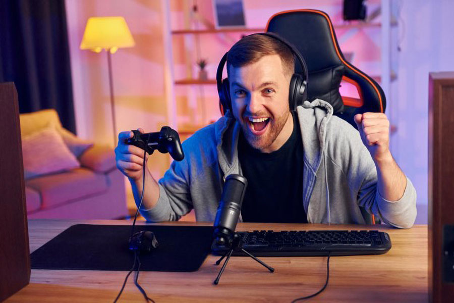 Picture of a Streamer in front of his setup being happy about gaining money via twitch. If you want to succeed it’s really important to find out how much money do gamers make on twitch.