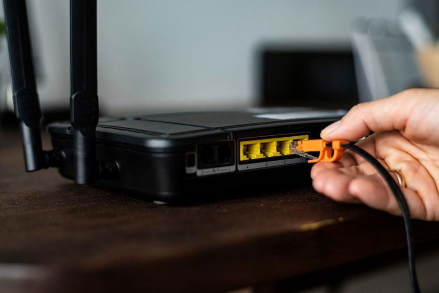 Picture of a Person Using LAN to Connect to a Router.