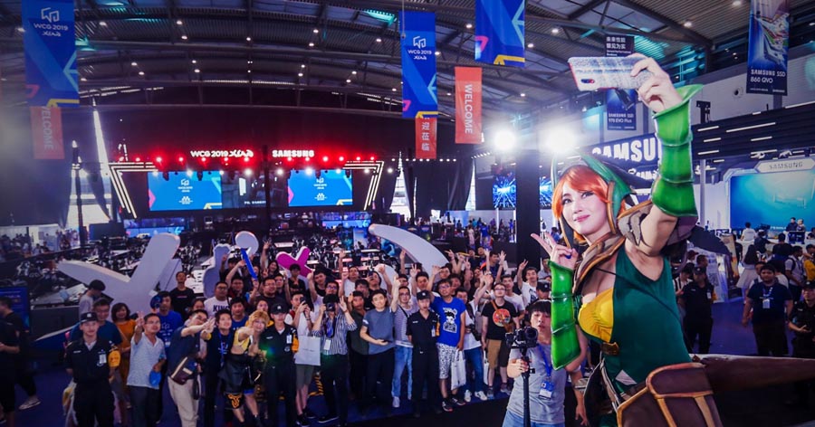 picture of a woman wearing custom dressing of game character taking selfie with a bunch of people.