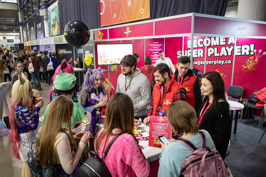 some girls and boys standing around a table in festival of Games Gathering Kyiv 2024.