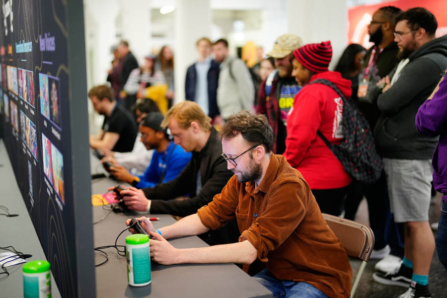 group of men in a room   working with phone in London Games Festival 2025.